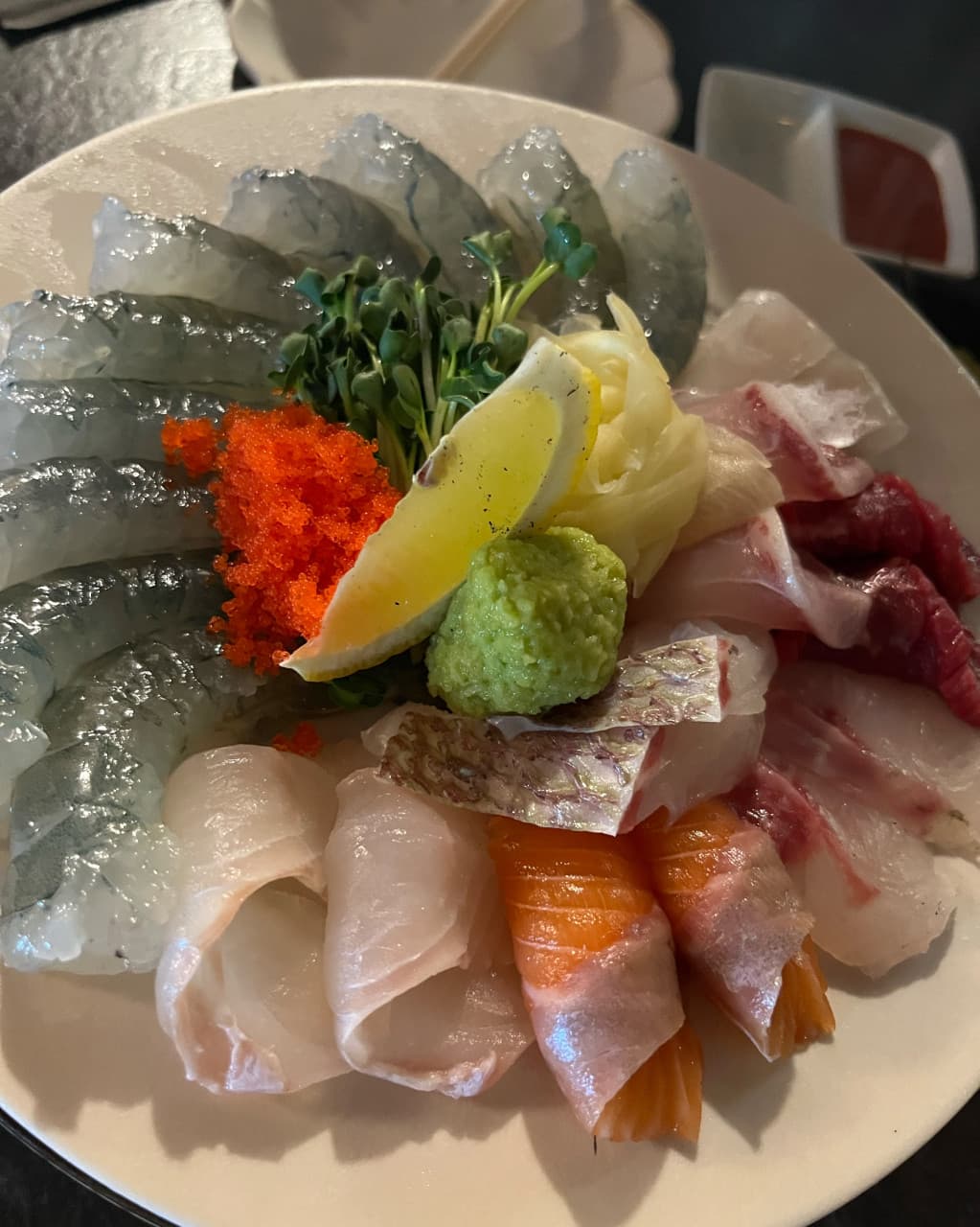 부산광역시 부산진구 무해한사이 전포동점 부산 요리주점 다찌석 조명 아래 놓인 1인 사시미. 생새우와 연어, 날치알의 질감이 돋보이는 접시로 혼술하는 상황을 표현함.
