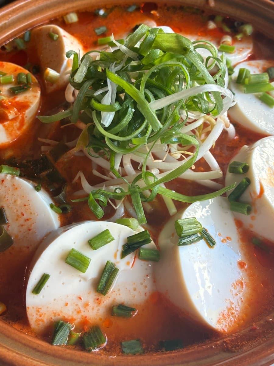 부산광역시 동래구 요리주점 하이바 동래점 부산 다찌석 1인 혼술. 밝은 조명 아래 붉은 국물 속 매끄러운 순두부와 수북한 파채, 숙주의 질감이 강조됨.
