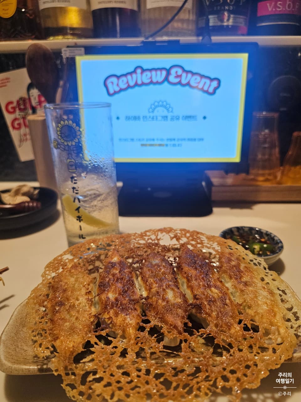 부산광역시 동래구 하이바 동래점 부산 요리주점 다찌석에 놓인 바삭한 눈꽃 교자와 레몬 하이볼. 태블릿 화면 앞 1인 카운터 좌석에서 조명과 함께 혼술을 즐기는 상황.