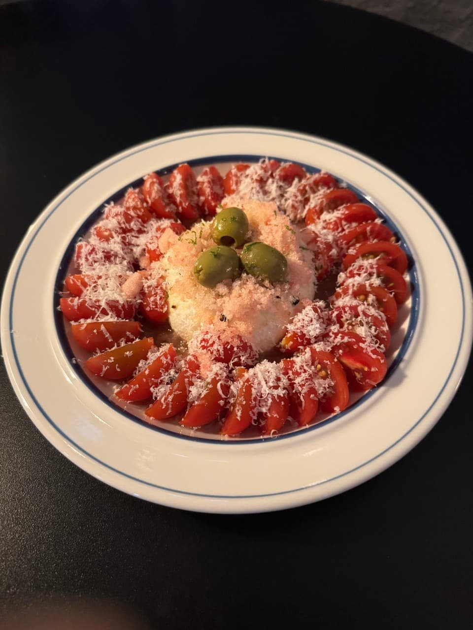 부산광역시 수영구 바(Bar) 표류 부산 다찌석 조명 아래 1인 혼술 메뉴로 차려진 토마토 치즈 샐러드. 검은 테이블 위 흰 접시에 담긴 식재료의 질감과 색채 대비.