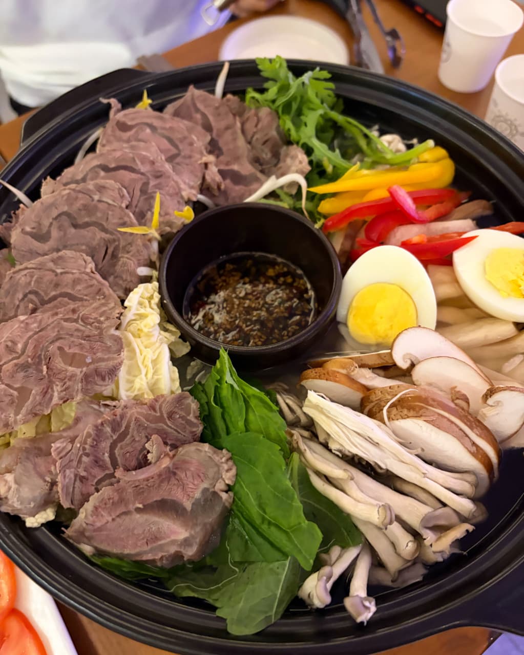 부산광역시 수영구 광안야행 부산 요리주점 다찌석에서 즐기는 1인 소고기 전골. 노란 조명 아래 고기와 채소가 가지런히 담긴 전골 냄비가 놓인 혼술 상황을 시각적으로 묘사함.