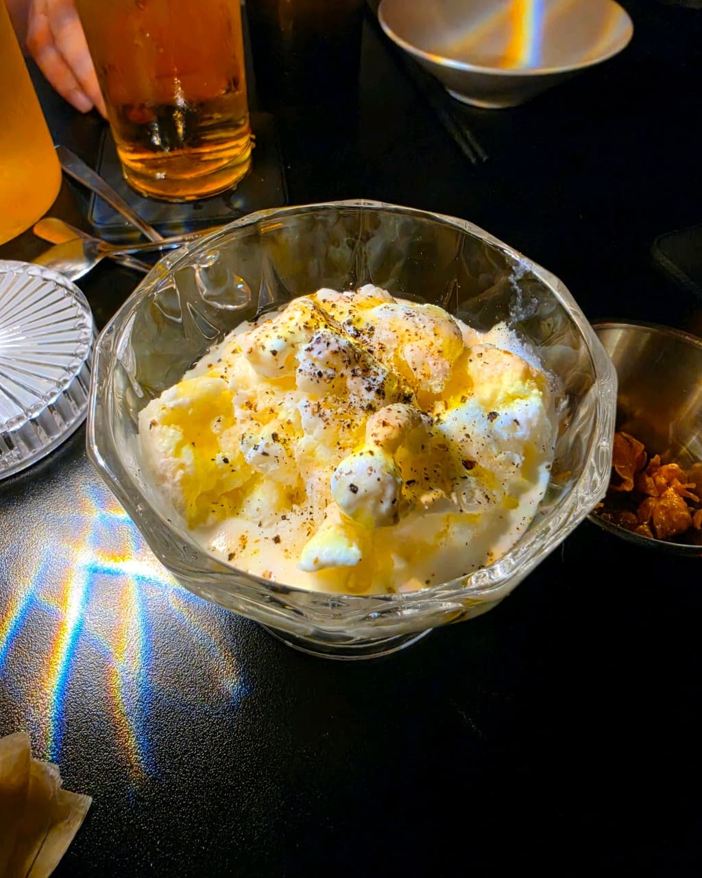 대전광역시 서구 이자카야 비어스탠드쿠모와리 대전 다찌석 혼술 상황. 무지개 조명이 투사된 검은 테이블 위 후추를 뿌린 바닐라 아이스크림과 생맥주가 놓인 모습.