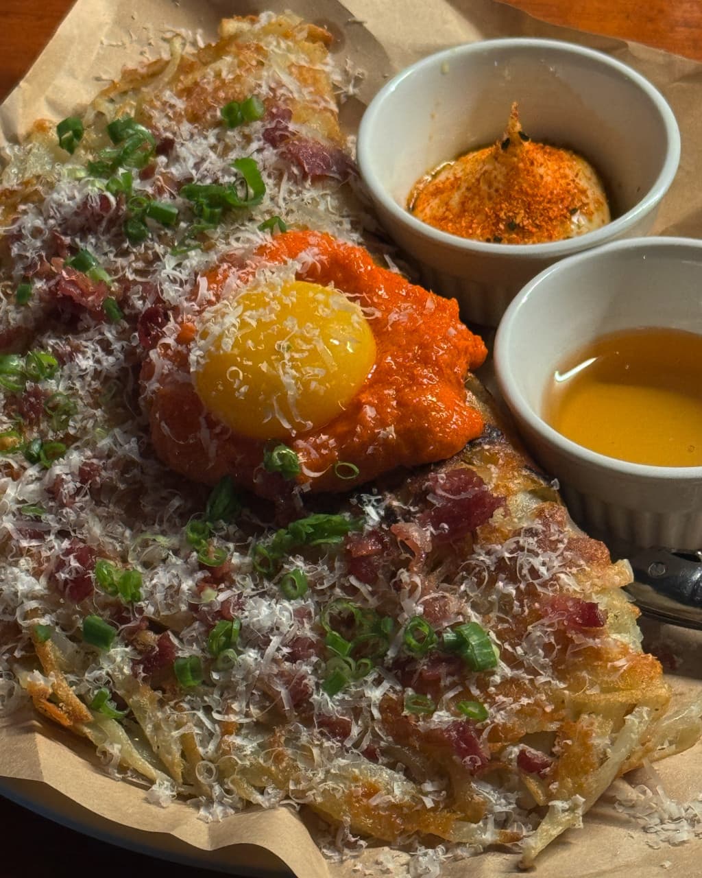 대전광역시 서구 혼술 이자카야 비어스탠드쿠모와리 대전, 조명 아래 다찌석에 놓인 노른자와 치즈 가루가 뿌려진 감자채전과 마요네즈 소스