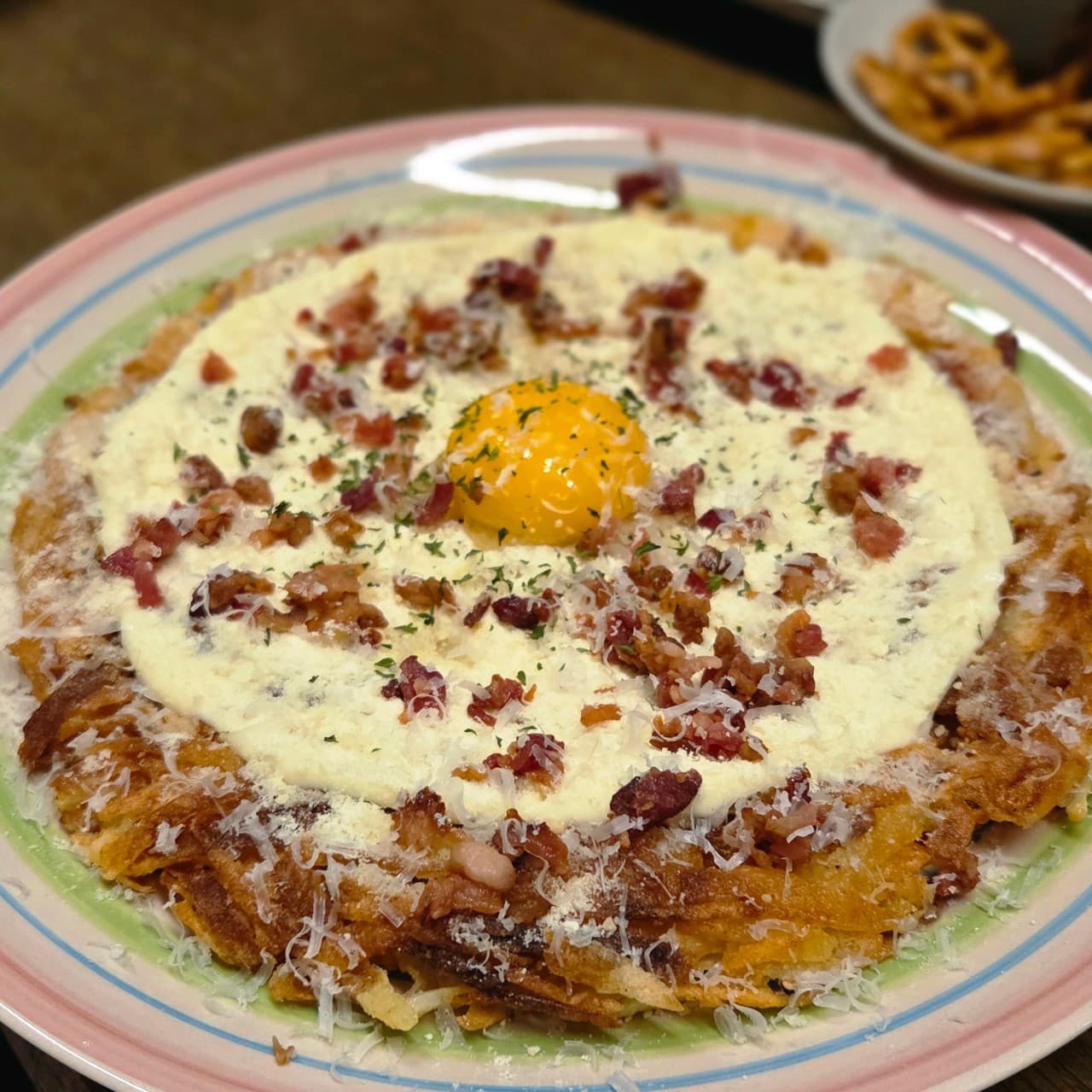 대전광역시 서구 요리주점 사랑사랑방 대전의 1인 다찌석 조명 아래 차려진 감자채전. 노란 계란 노른자와 베이컨이 올라간 안주의 바삭한 질감과 하얀 소스가 어우러진 혼술 상황.