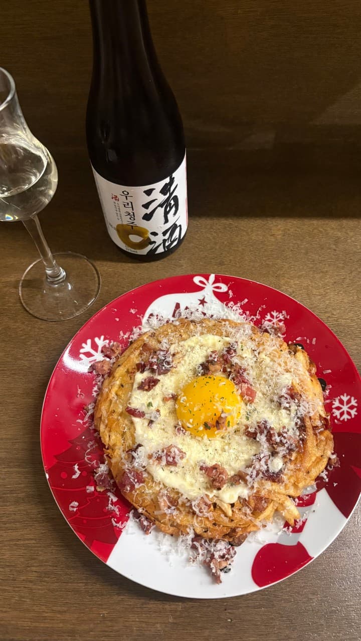대전광역시 서구 요리주점 사랑사랑방 대전의 나무 다찌석. 노른자와 치즈가 토핑된 바삭한 감자전과 전통주가 차려진 1인 혼술 상황. 조명 아래 놓인 술병과 유리잔.