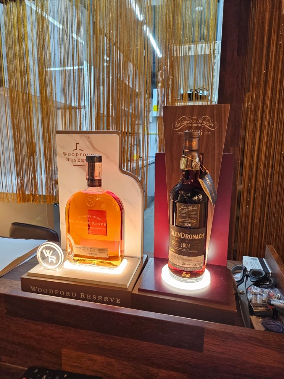 대전광역시 서구 보리보틀 대전 맥주 호프 다찌석에 조명과 함께 진열된 우드포드 리저브와 글렌드로낙 위스키. 1인석 카운터 테이블에서 즐기는 혼술 상황.