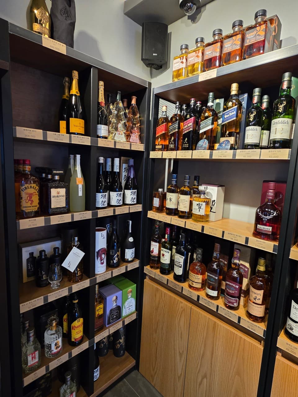 대전광역시 서구 보리보틀 대전 맥주 호프 매장. 진열장에 나열된 다양한 위스키와 사케 등 1인 혼술을 위한 주류와 가격표가 선반에 정돈된 모습.