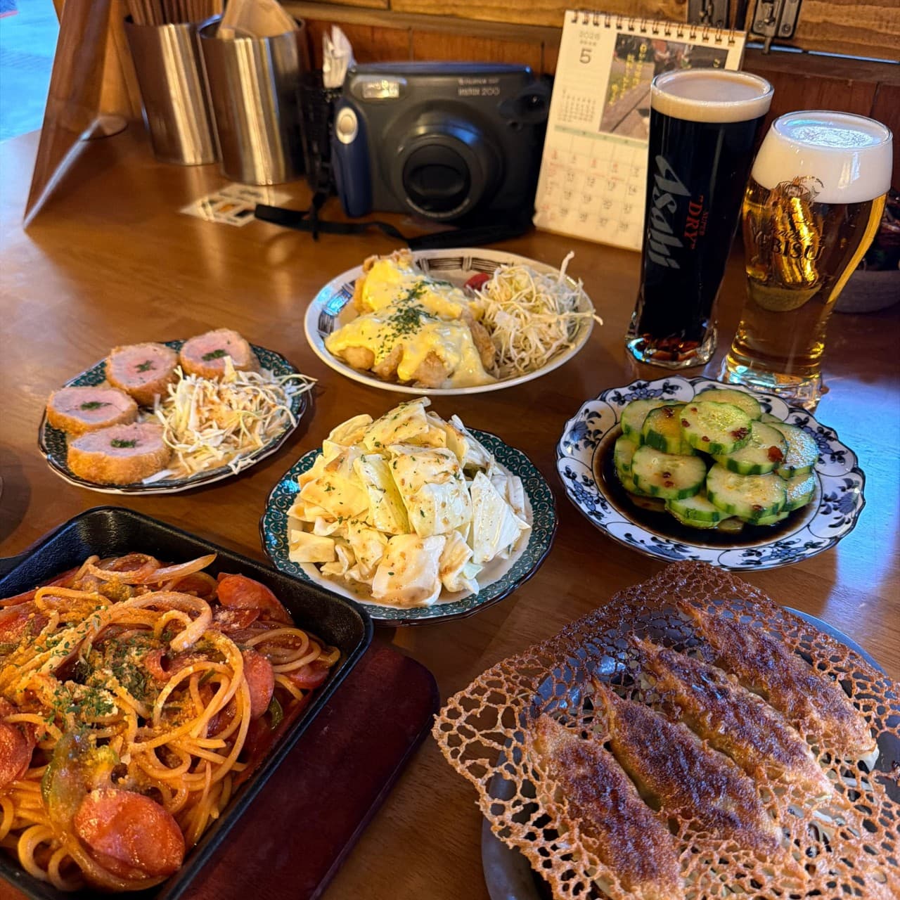 대전광역시 유성구 타치노미 럽밤 대전 맥주 호프 1인 다찌석. 나폴리탄 파스타와 바삭한 교자, 생맥주가 차려진 혼술 상황. 따뜻한 조명이 비치는 나무 테이블 위 음식의 질감.