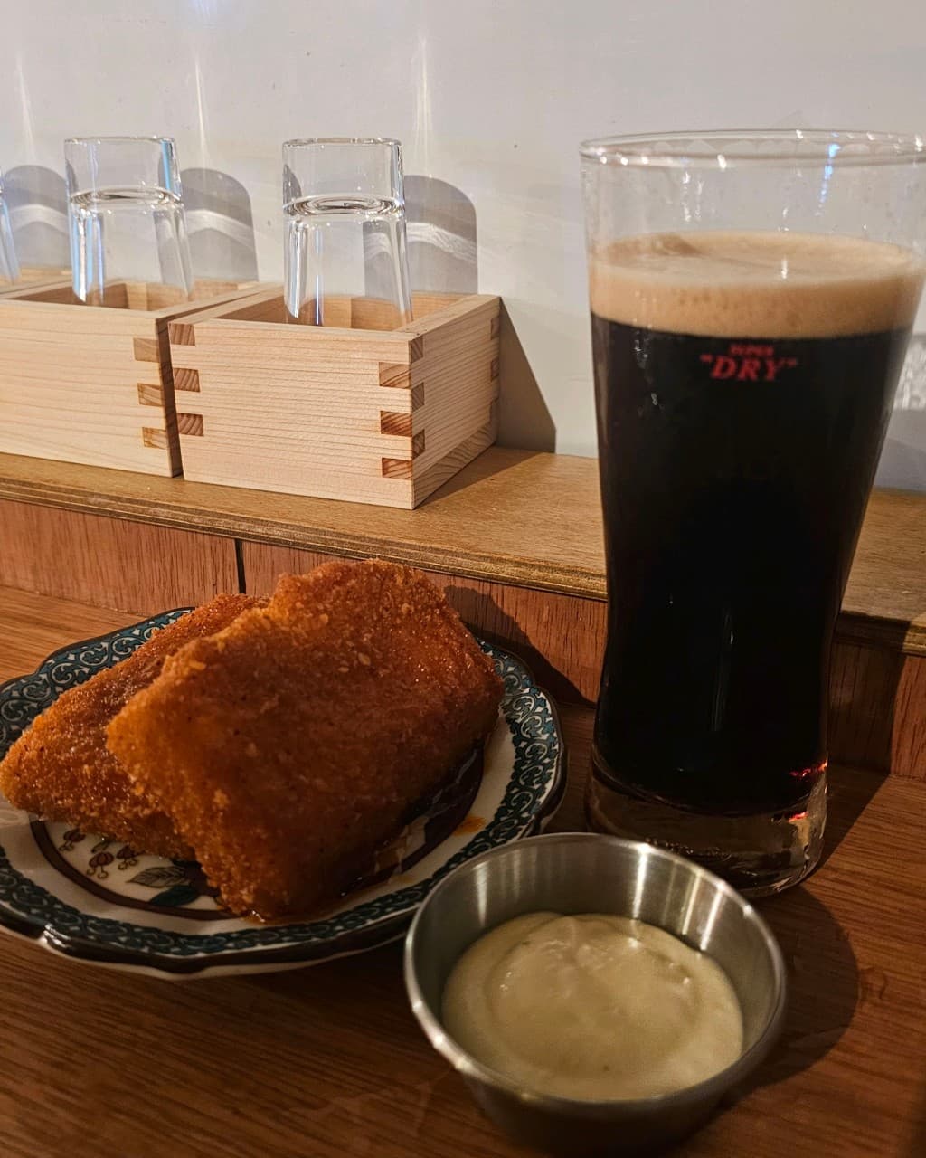 대전광역시 유성구 타치노미 럽밤 대전 맥주 호프 다찌석. 거품 섞인 흑맥주와 바삭한 튀김이 놓인 1인 테이블 위로 조명이 비치는 혼술 상황.