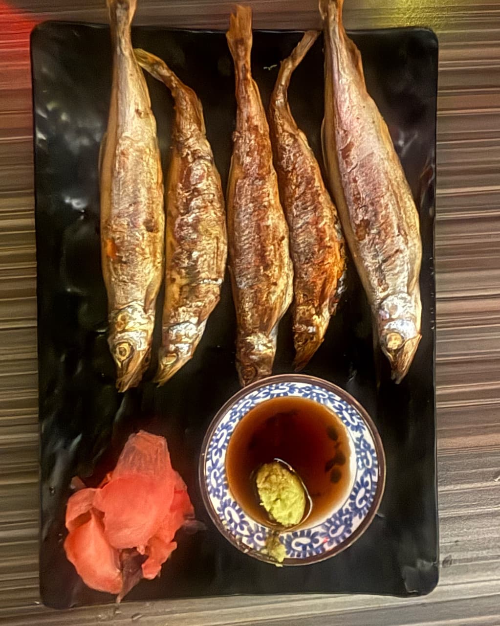 인천광역시 남동구 하나마토 인천논현 요리주점 다찌석 조명 아래 차려진 1인 시샤모 구이와 간장 소스. 노릇하게 구워진 생선 질감이 드러나는 혼술 상차림.