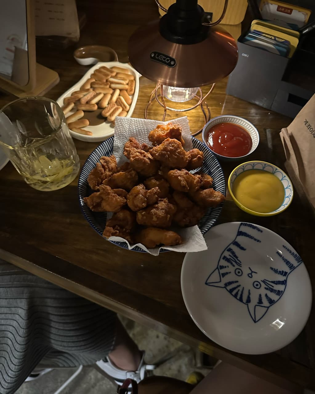 제주특별자치도 제주시 곁 제주혼술바 탑동점 본점 바(Bar)의 램프 조명 아래 차려진 치킨과 하이볼. 1인 다찌석에서 혼술을 즐기는 상황을 묘사함.