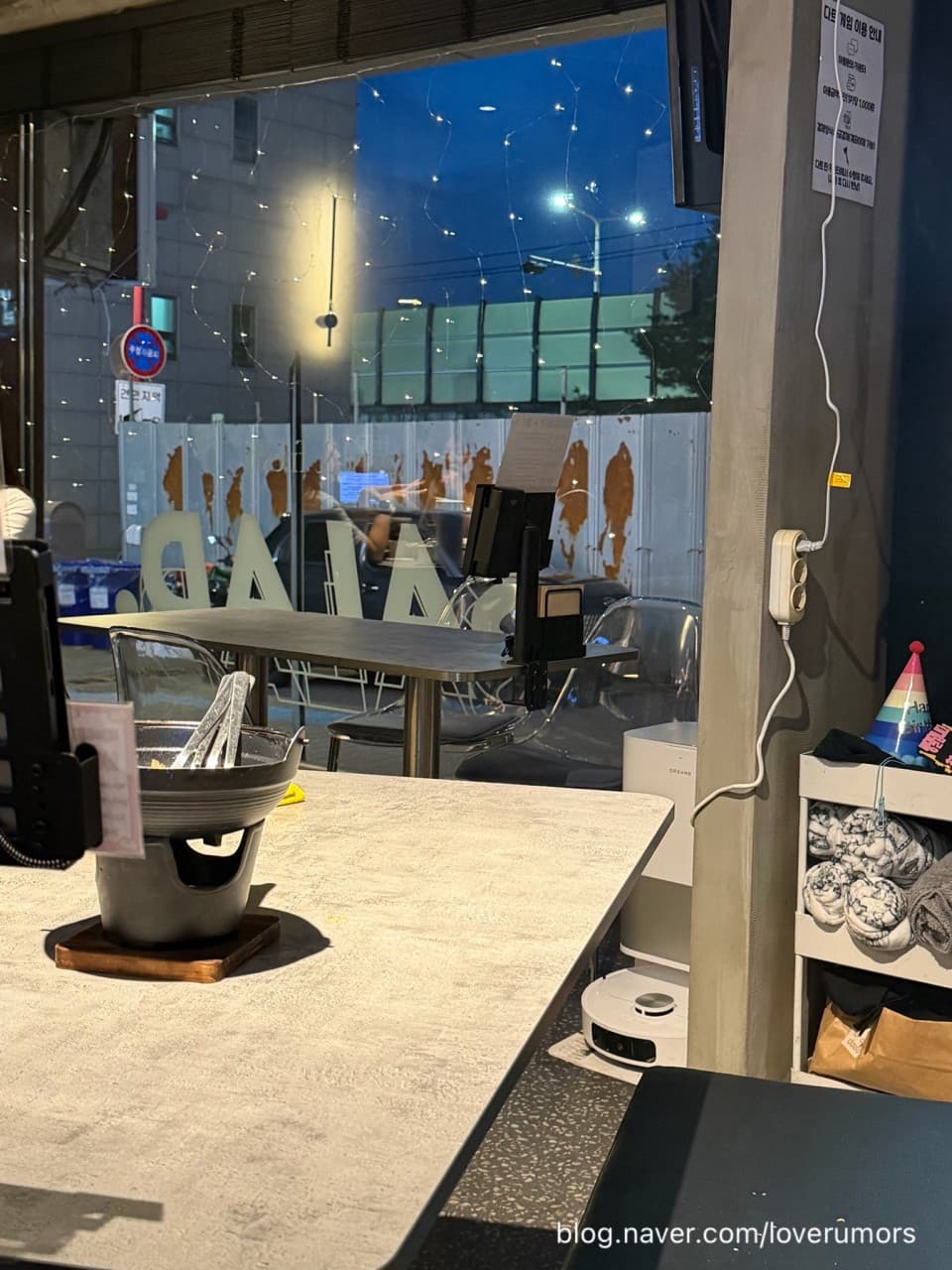 경기도 수원시 작은바와 서양면집 성대역본점 경기 요리주점 - 창밖 밤 풍경과 전구 조명이 비치는 다찌석 위 1인용 전골 냄비가 놓인 혼술 공간