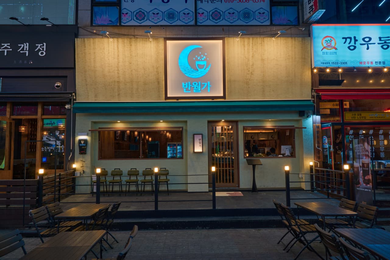 경기도 안산시 요리주점 반월가 경기 외부. 노란 조명이 켜진 야외 테이블과 창문 너머 혼술이 가능한 1인 다찌석이 배치된 구조를 보여줌.