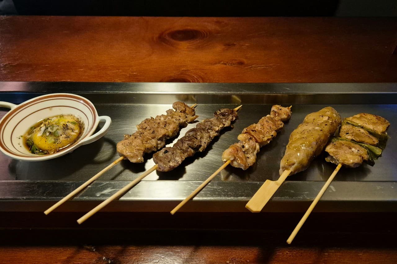경기도 수원시 요리주점 도리토리 수원곡반정점 경기 1인 다찌석 혼술. 조명 아래 금속 쟁반 위 육즙 있는 닭꼬치 5종과 계란 노른자 소스 및 나무 테이블.