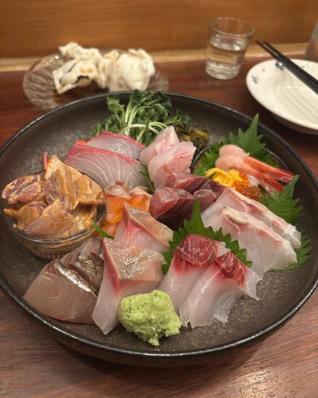 경기도 성남시 이자카야 키리모리 본점 경기 다찌석에 차려진 모둠 사시미. 참치와 단새우의 윤기 나는 질감이 조명 아래 강조되며 혼자 술을 즐기는 상황을 보여줌.