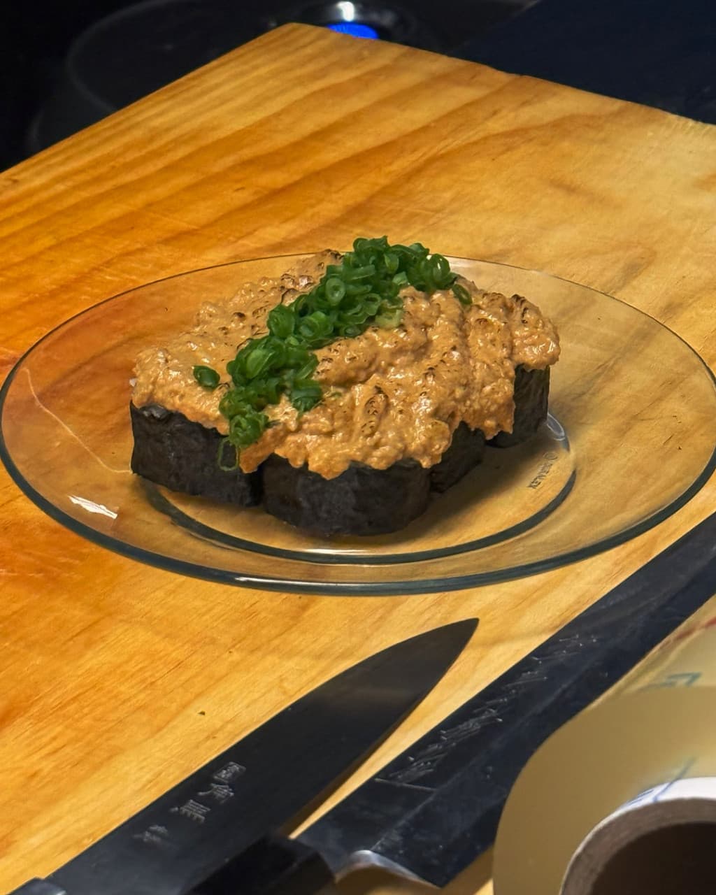 경기도 하남시 1인 혼술 식당 옥여 경기 - 나무 다찌석 위 소스가 올라간 마끼와 대파 고명의 질감 및 조명 아래 놓인 칼이 있는 기타 음식점