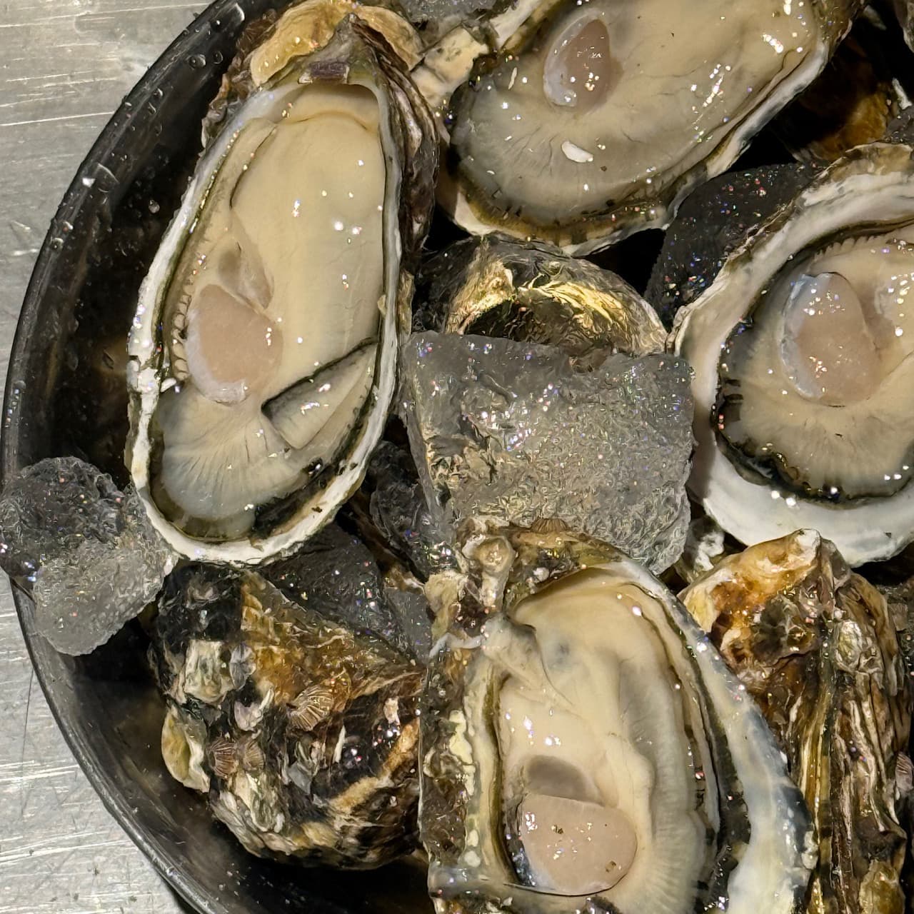 경기도 하남시 혼술 매장 옥여 경기 - 다찌석 조명 아래 얼음 위 신선한 석화의 질감이 강조된 1인 안주가 놓인 기타 업종 식당 분위기
