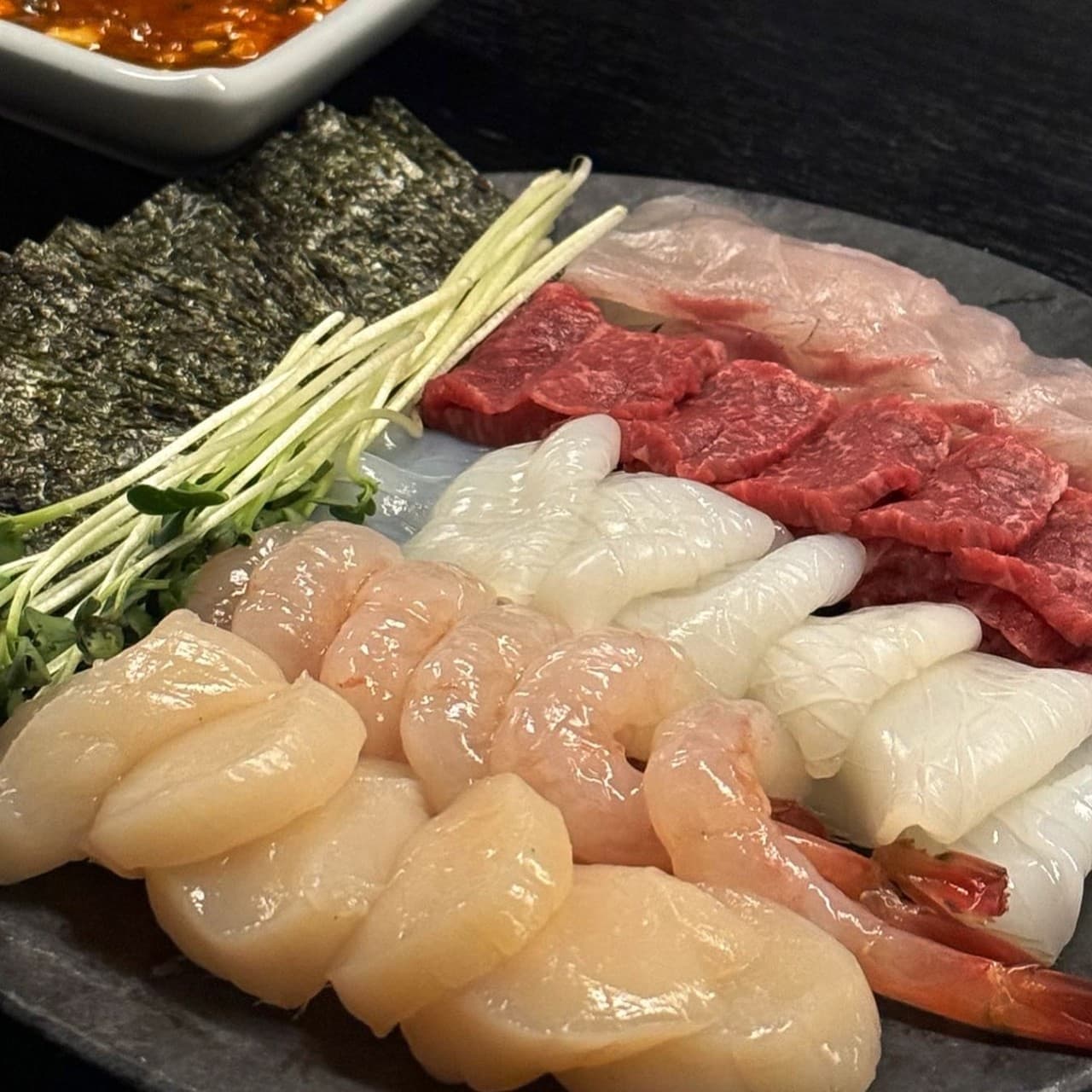 경기도 하남시 옥여 경기 1인 혼술 차림. 조명 아래 윤기 나는 관자와 단새우, 육사시미가 김과 무순 옆에 나란히 놓인 다찌석의 식사 상황.