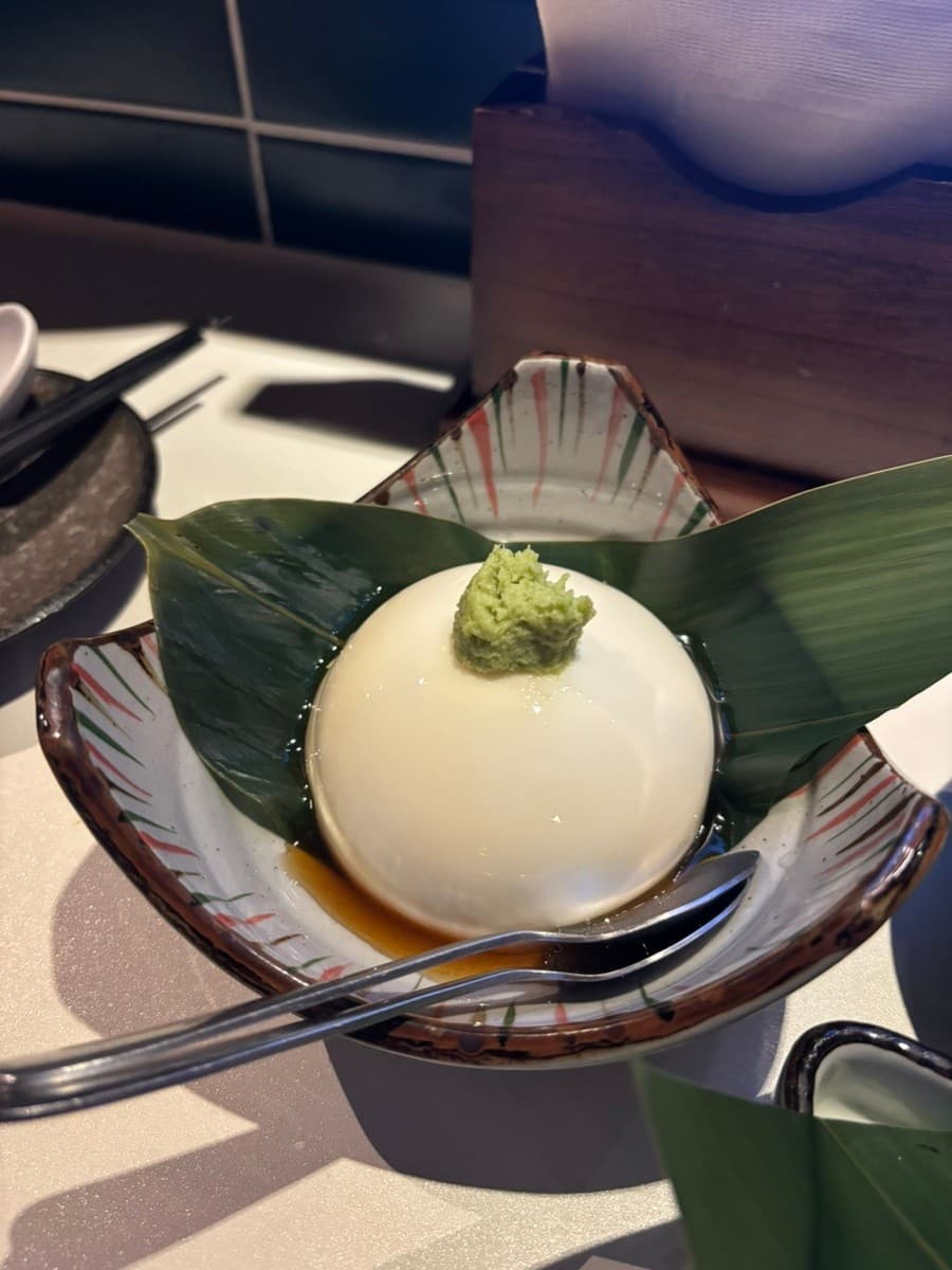 경기도 용인시 이자카야 리버브 경기 다찌석 조명 아래 놓인 1인 모찌리도후. 나뭇잎 위에 와사비를 얹은 탱글한 두부와 전용 소스가 담긴 그릇이 있는 혼술 상황.