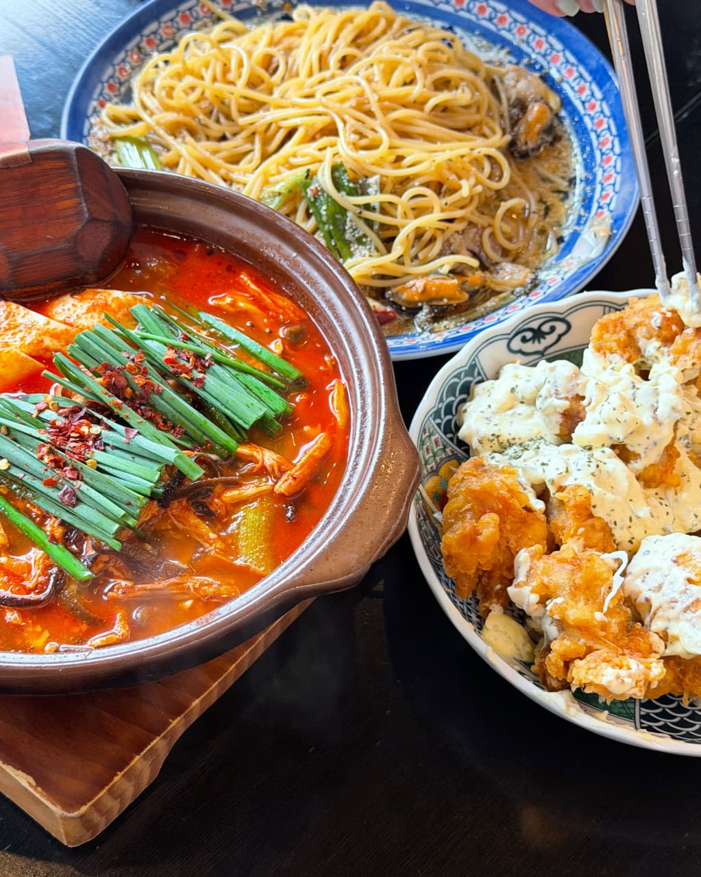 경기도 고양시 이자카야 심야식당 세솔리 경기 다찌석 혼술. 부추가 올라간 붉은 전골과 오일 파스타, 소스를 곁들인 바삭한 가라아게가 차려진 1인 식사 상황.