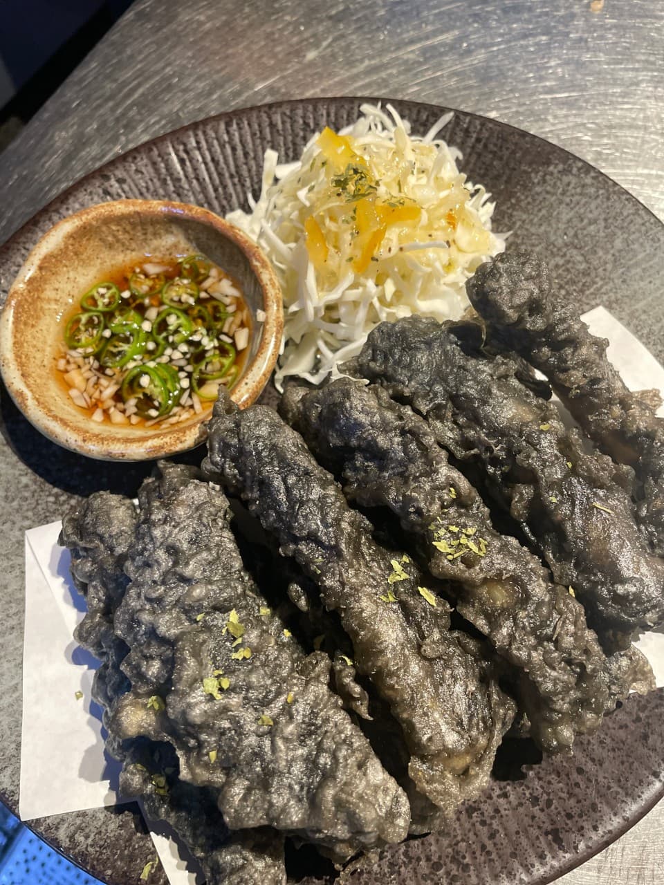 대구광역시 달서구 혼술 영남막회초장 상인본점 대구 - 다찌석 조명 아래 바삭한 검은색 튀김과 양배추 샐러드 1인 차림