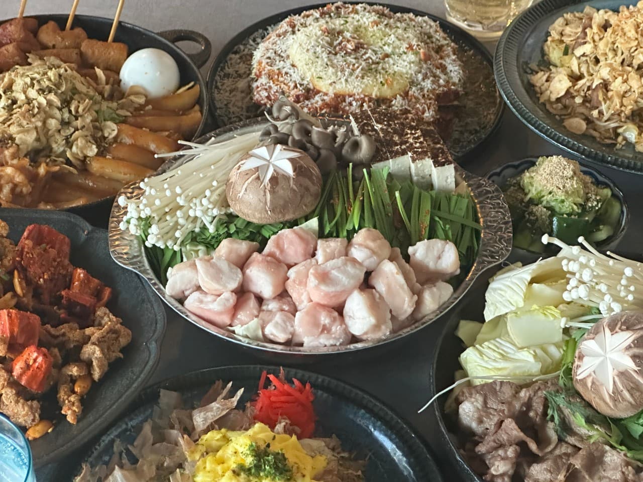 인천광역시 서해구 이고식당 인천 이자카야의 1인 다찌석. 대창 나베와 스키야키 등 다양한 메뉴가 차려진 혼술 상차림. 따뜻한 조명 아래 식재료의 선명한 질감과 색감이 강조됨.