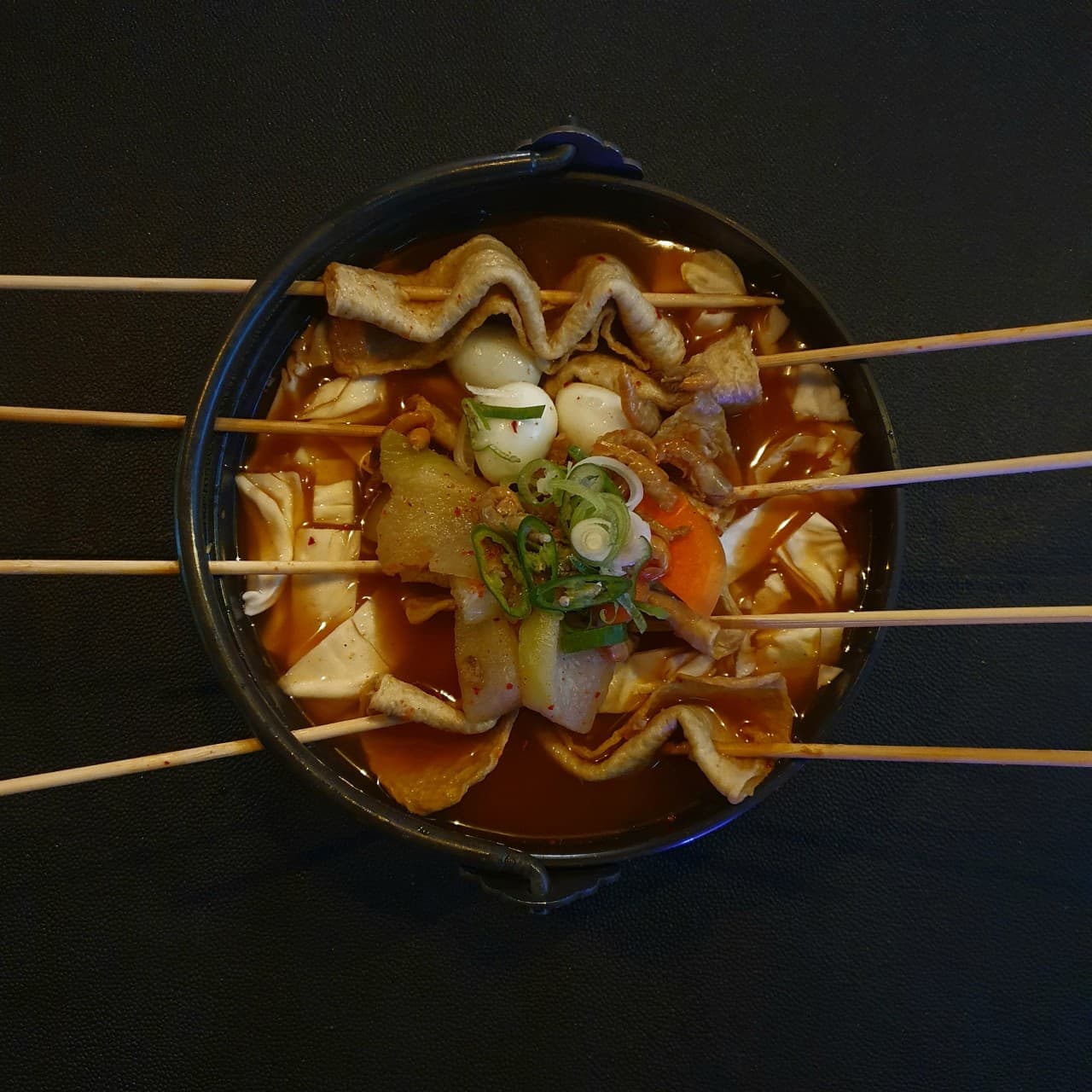 인천광역시 영종구 요리주점 촤랑 인천 혼술 - 어두운 조명 아래 다찌석 위 꼬치어묵과 메추리알이 담긴 1인분 어묵탕 냄비