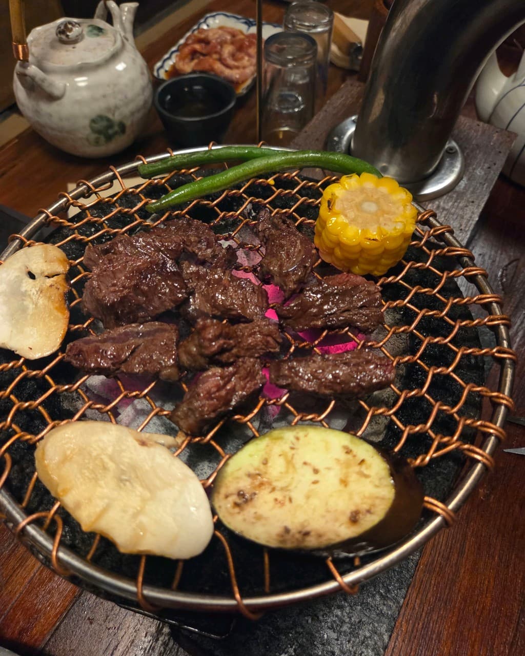 세종특별자치시 한누리대로 청양 세종본점의 다찌석 1인 혼술. 숯불 화로 위 석쇠에 놓인 소고기와 채소 등 기타 식재료가 구워지는 상황.