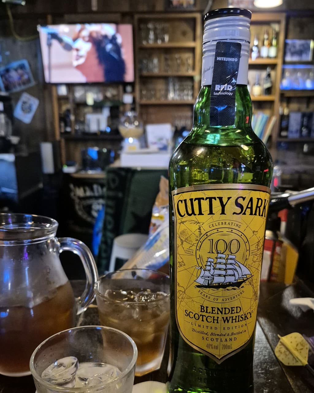 충청북도 제천시 보틀넥 바(Bar) 원목 카운터 위 커티샥 위스키병과 얼음 가득한 잔. 나무 선반 배경의 노란 조명 아래 혼술 중인 상황.