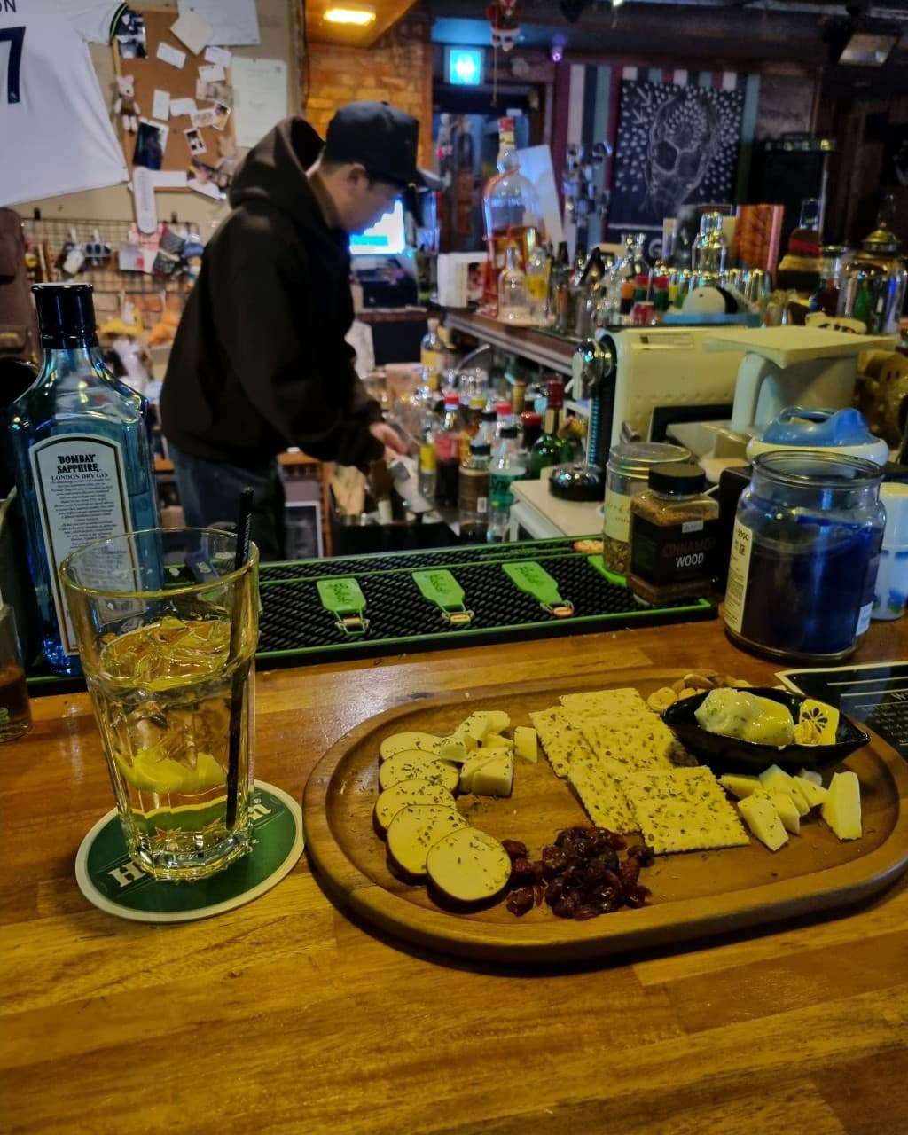 충청북도 청주시 라온 바(Bar)의 나무 다찌석에서 즐기는 혼술. 주황색 조명 아래 크래커와 치즈 플래터, 레몬 하이볼이 차려진 1인석 상황.