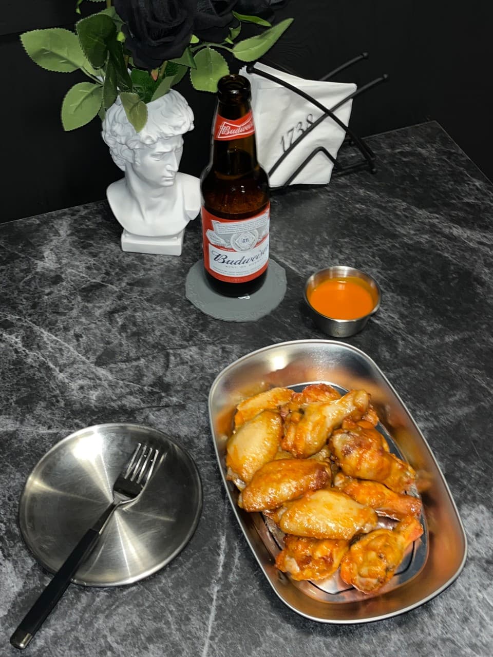 충청북도 충주시 1738pub 연수점 바(Bar) - 대리석 다찌석 위 버드와이저 병맥주와 윤기 흐르는 버팔로윙이 차려진 1인 혼술 상황
