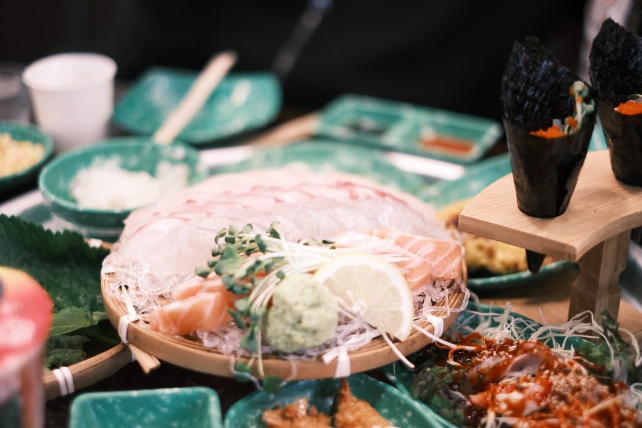 충청북도 청주시 요리주점 회오리 청주율량점 다찌석에 차려진 1인 사시미와 김마끼. 은은한 조명 아래 연어의 질감과 정갈한 찬들이 돋보이는 혼술 상황.