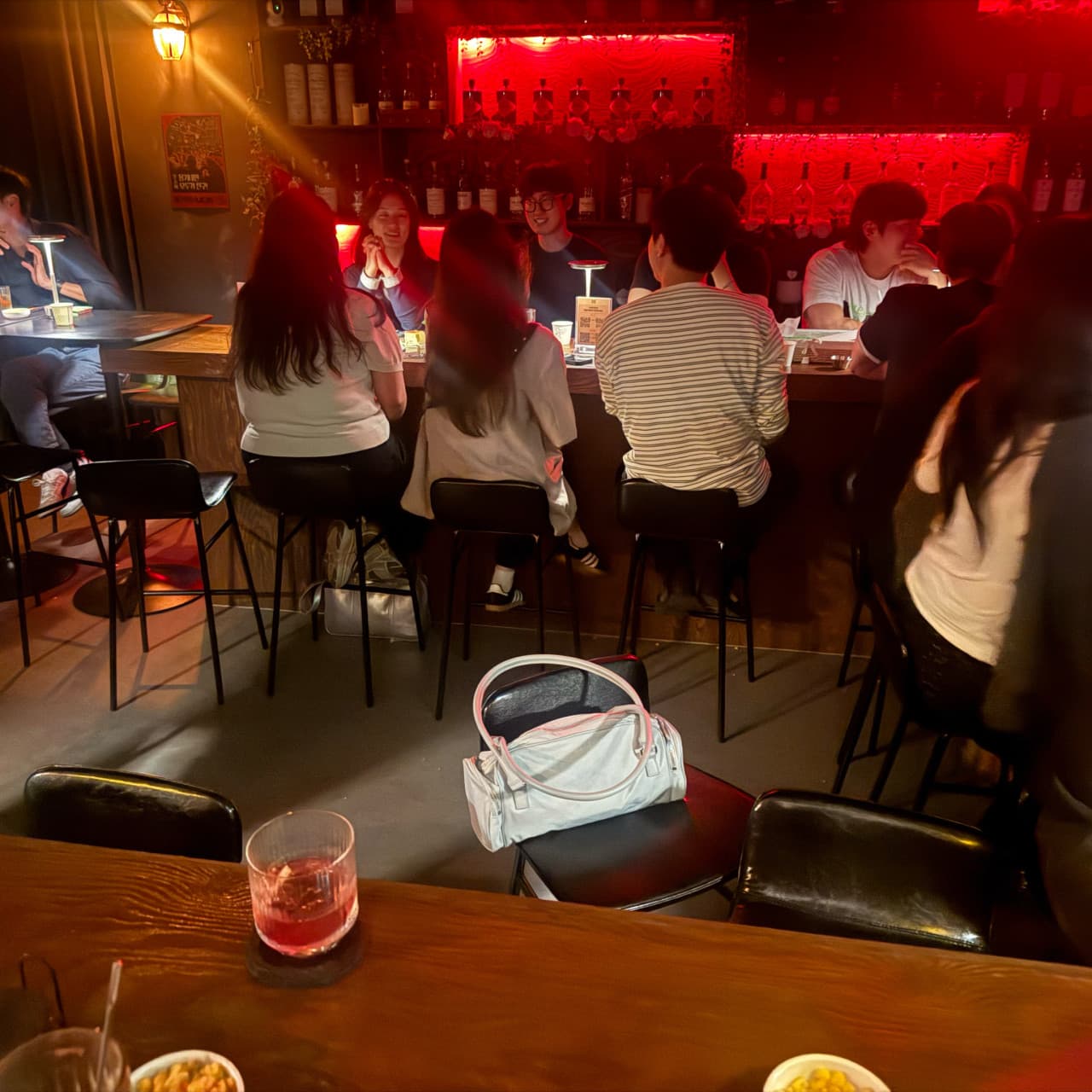 충청남도 천안시 제주아홉 혼술바 천안신불당점 - 붉은 조명 아래 다찌석과 1인 카운터 테이블에 놓인 붉은 칵테일. 혼술을 하는 바(Bar) 내부 상황.
