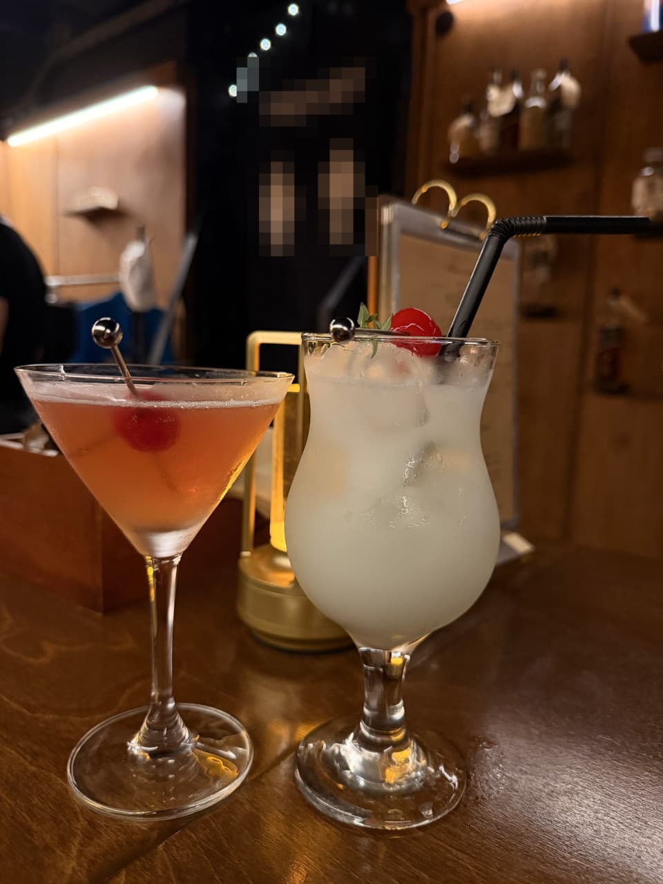 충청남도 천안시 혼술바 고도 천안점 바(Bar) - 나무 다찌석 위 조명을 받은 붉은색과 흰색 칵테일. 체리 고명이 더해진 1인 술자리 상황.